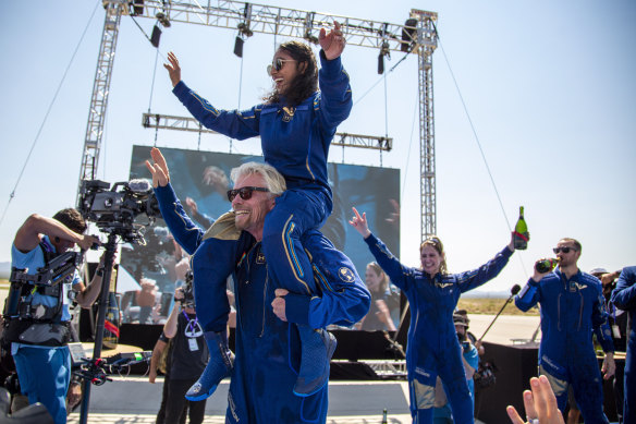 Virgin Galactic founder Richard Branson carries crew member Sirisha Bandla on his shoulders while celebrating their flight to space. 