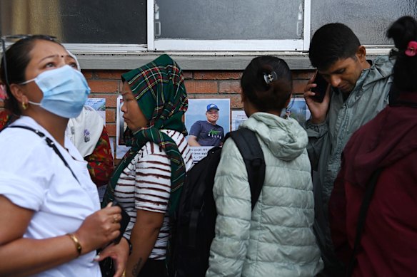 People gather to look at posters of people missing in the Nepal flood disaster.