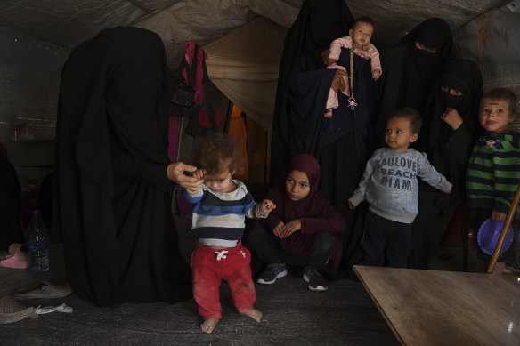 Australian women and children gather in a tent in the al-Hawl camp where they watch Omeid, who suffers with spinal deformities and malnutrition, attempt to walk.
