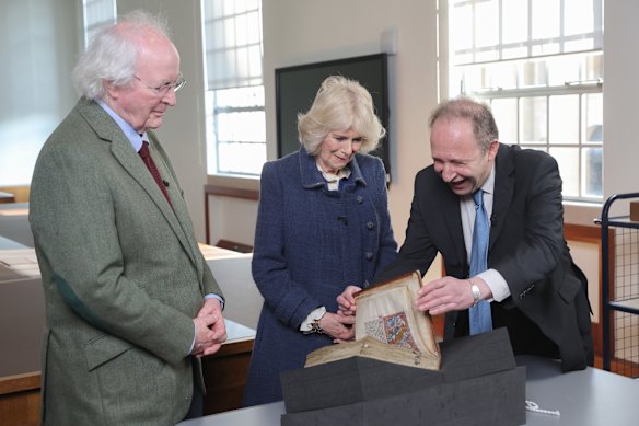 Camilla, Duchess of Cornwall and author Philip Pullman (left) view a book with Dr Martin Kauffmann at the Bodleian Library at the University of Oxford in 2022.