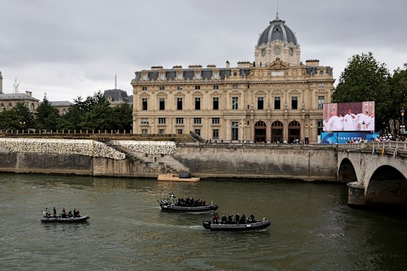 Members of Raid, France’s police intervention unit, patrol the Seine River in front of Paris’ commercial court prior to the opening ceremony.