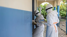 Health workers take meals to Ebola patients at the treatment center in Rwampara, Congo.