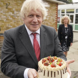Johnson holds up a birthday cake - baked for him by staff during a school visit in June 2020.