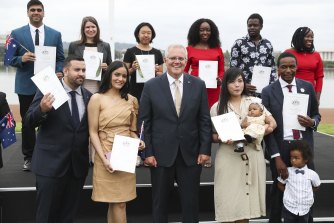 Prime Minister Scott Morrison poses  with new citizens during the Australia Day flag raising and citizenship ceremony in Canberra. 