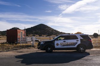 A Santa Fe County Sheriff’s deputy briefly talks with a security guard at the entrance to the Bonanza Creek Ranch, the set of Rust, in Santa Fe.