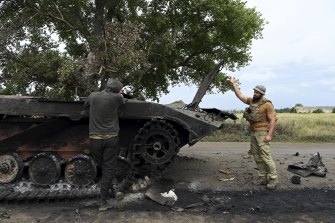 İki Ukraynalı asker, Donetsk Oblastı'nın Bakhmut Raion'unda Siversk yakınlarındaki bir yolda tahrip olmuş bir tankı inceliyor. 