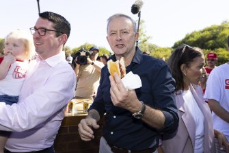 Anthony Albanese grabs a sausage  sandwich during a campaign visit to Perth last month.