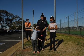 Latisha Carr-McEwan with her children waiting in a queue for a COVID-19 test at the Dubbo West walk-in clinic.