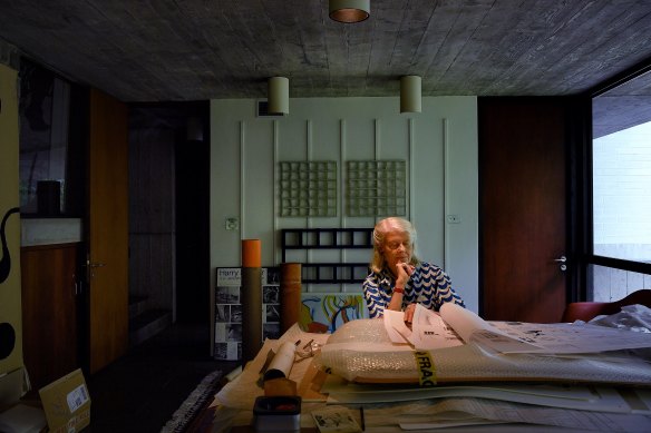 Penelope Seidler at her husband Harry’s drafting desk at her home in Killara, with sculptures by Hilarie Mais behind.