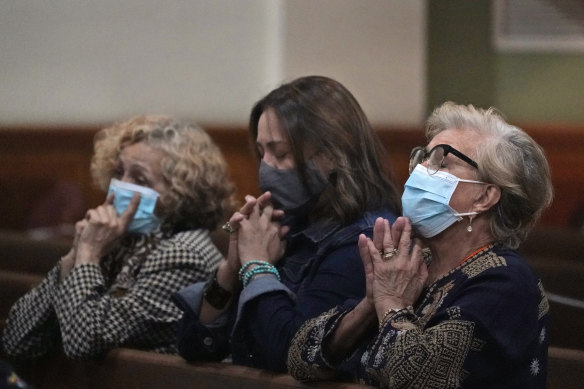 Women pray, late on Saturday, at a vigil for the victims and families of the Champlain Towers collapsed building in Surfside, Florida, at the nearby St. Joseph Catholic Church in Miami Beach.