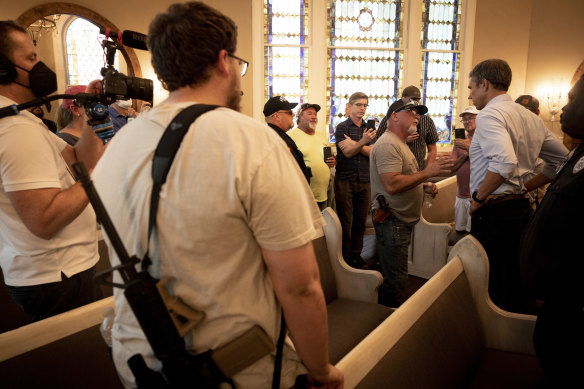 Beto O’Rourke, right, the Democratic candidate for governor, speaks with Rod Parker, a revivalist preacher with a .40-caliber handgun who had been protesting outside, in Whitesboro, Texas in July.