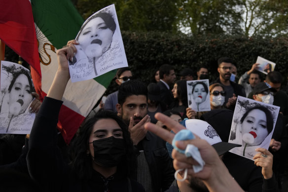Göstericiler Pazar günü Londra'daki İran Büyükelçiliği önünde pankartlar taşıyorlar.