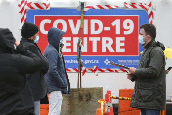 A staff member talks to people waiting to be tested for COVID-19 in Wellinton.