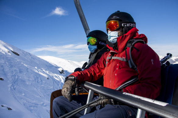 Skiers wearing face masks ride a chairlift on the opening day of the Verbier ski area in the Swiss Alps.