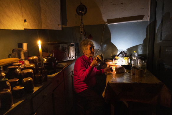 81 岁的娜塔莉·泽姆科 (Natalie Zemko) 在俄罗斯袭击受损发电厂后，在基辅电力受限后，在烛光下喝茶。