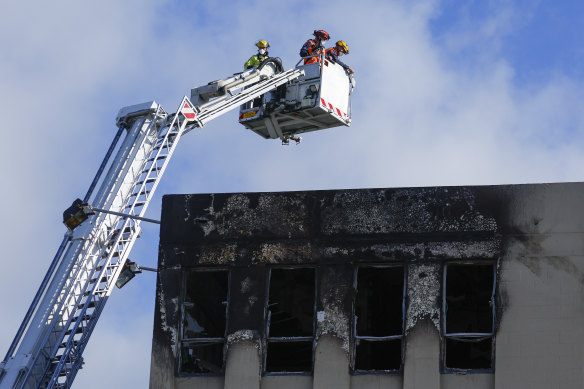 Fire Service staff survey roof damage the day after a fire at Loafers Lodge.