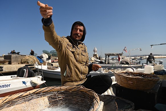 Fisherman Mehdi Istanbouli works on his lines at the port in Tyre. He is reluctant to go fishing while Israel is carrying out strikes in the city.