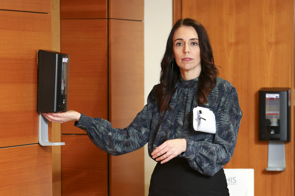 NZ Prime Minister Jacinda Ardern uses hand sanitiser as she leaves a press conference at Parliament House in Wellington on Friday.