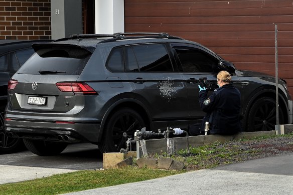NSW police collect evidence at Carnes Hill, which is now a crime scene after a 25-year-old male was shot. 
