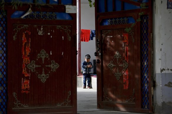 A Uighur child plays alone in the courtyard of a home at the Unity New Village in Hotan, in China’s Xinjiang region. There have been reports of forced sterilisations of the Uighurs by the government.