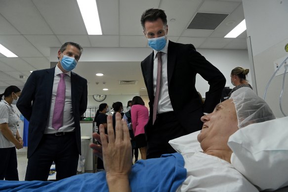 NSW Premier Chris Minns (right) and Health Minister Ryan Park (left) talk with a patient in the endoscopy ward at Liverpool Hospital.