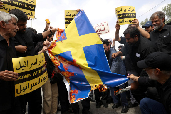 Demonstrators burn the Swedish flag during a protest in Tehran.