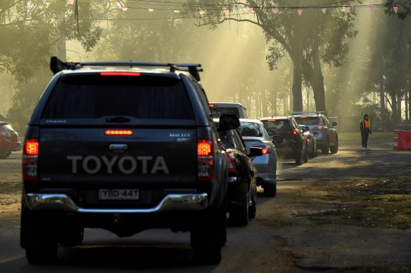 Cars queue to enter a COVID-19 test site at the Fairfield Showgrounds in south-western Sydney.