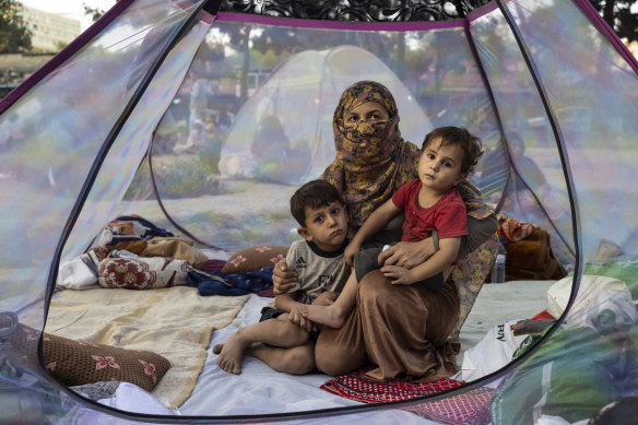 Farzia, 28, who lost her husband in fighting by the Taliban, with her children in a makeshift IDP camp in Kabul.