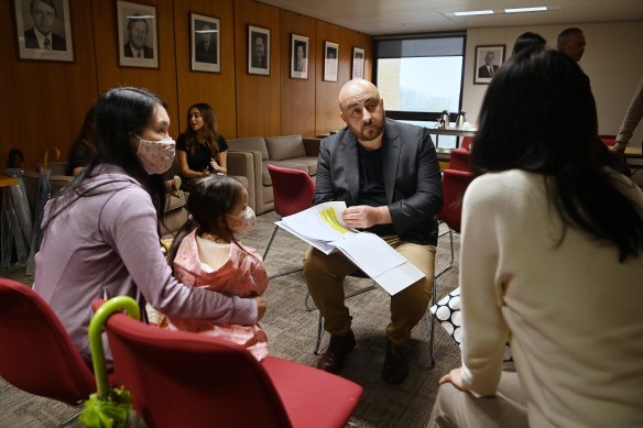 Mascot Towers owners Karee Chan with her daughter Cathleen Chan, age 2, and Stu Carr look through the letters residents have written to Premier Dominic Perrottet about their plight. 