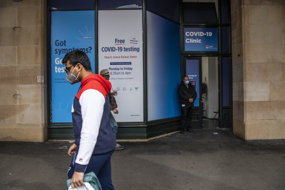 Masked pedestrians walk past a coronavirus testing clinic outside Central Station on Friday.