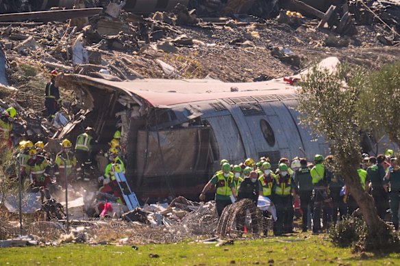 Emergency services climb through the wreckage where many passengers died.