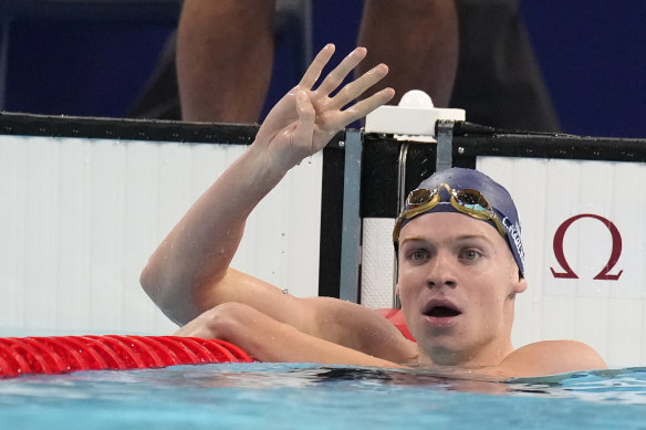 Leon Marchand holds up four fingers for his four gold medals after winning the men’s 200m individual medley.