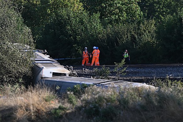 Emergency services workers examine the damage.