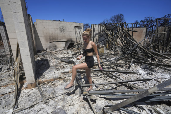 Sydney Carney walks through her home, which was destroyed by wildfire, in Lahaina, Hawaii on Friday.