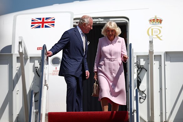 A Rainha Camilla, usando um broche com as bandeiras britânica e norte-americana, chega com o Rei Charles.