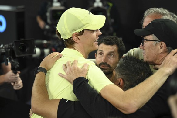 Australian tennis coach Darren Cahill (far right) is embraced by Sinner.