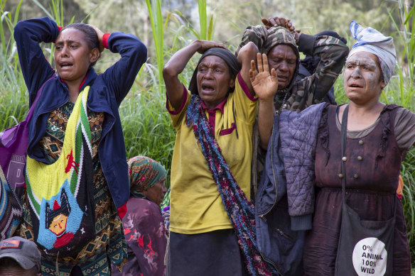 Grieving villagers in the devastated the village of Yambali.