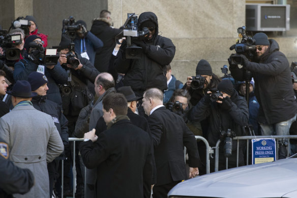 A line had formed early in the morning to see Weinstein, centre, arrive at the Lower Manhattan court. 