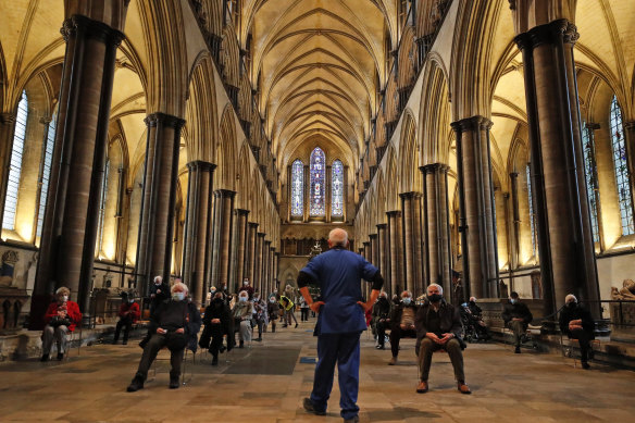 A medic monitors people who sit and wait after receiving their vaccine at Salisbury Cathedral. 