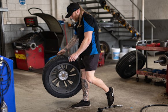 A tyre technician working at Tyre & More, Parramatta. 