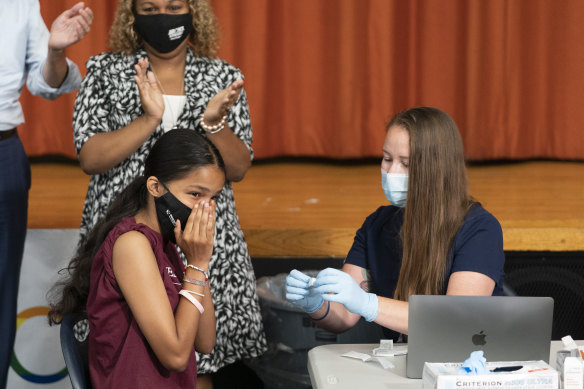 Ariel Quero, 16, left, a student at Lehman High School, gets her jab in New York.