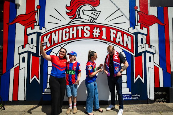 Newcastle Knights fans take selfies in front of a Knights mural at The Goodfriends Eatery at The Junction, Newcastle on Thursday.