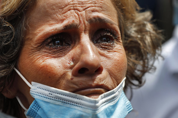 A woman in tears waits outside the port for news about her missing son.