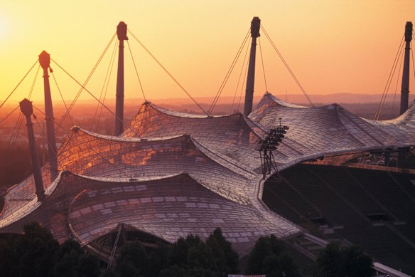 The wave-like roof of the 1972 Munich Olympic Stadium pictured at sunset.