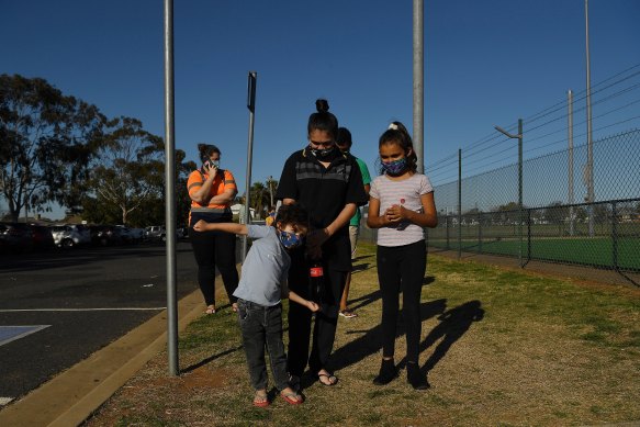 Latisha Carr-McEwan with her children waiting in a queue for a COVID-19 test at the Dubbo West walk-in clinic.