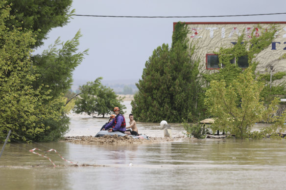 Firefighters evacuate people and dogs from a flooded building in Larissa, central Greece, on Wednesday.
