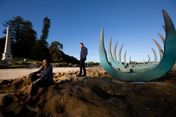 Alison Page and Dillon Kombumerri with sculpture 'The Eyes of the Land and Sea' at Captain Cook's landing place in Kamay Botany National Park. 