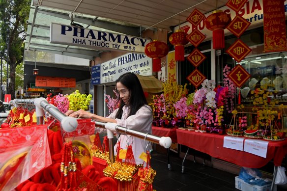 A woman organising traditional Vietnamese decorations on sale in preparation for New Year’s Eve on Chapel Road.