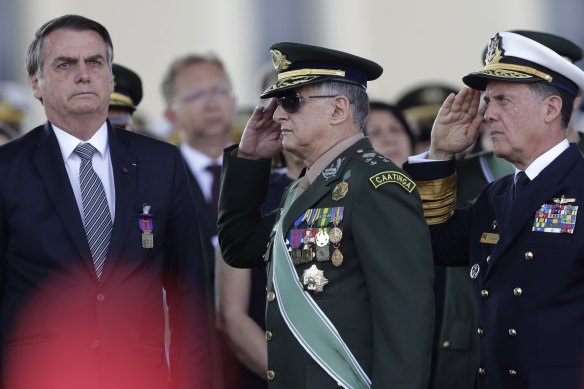 Brazil’s President Jair Bolsonaro, left, receives military honours in 2019.