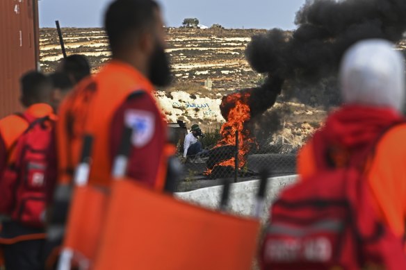 Volunteer first aid responders watch a Palestinian youth during clashes with the Israeli military near the al-Jalazone refugee camp in Ramallah, West Bank.